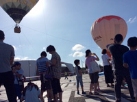 夏空を見上げて気球に乗るのを待つワクワク